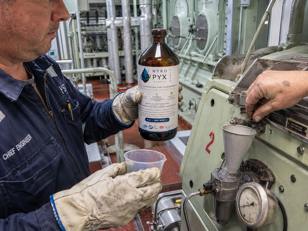 Chief engineer holding NTROPYX bottle near engine machinery
