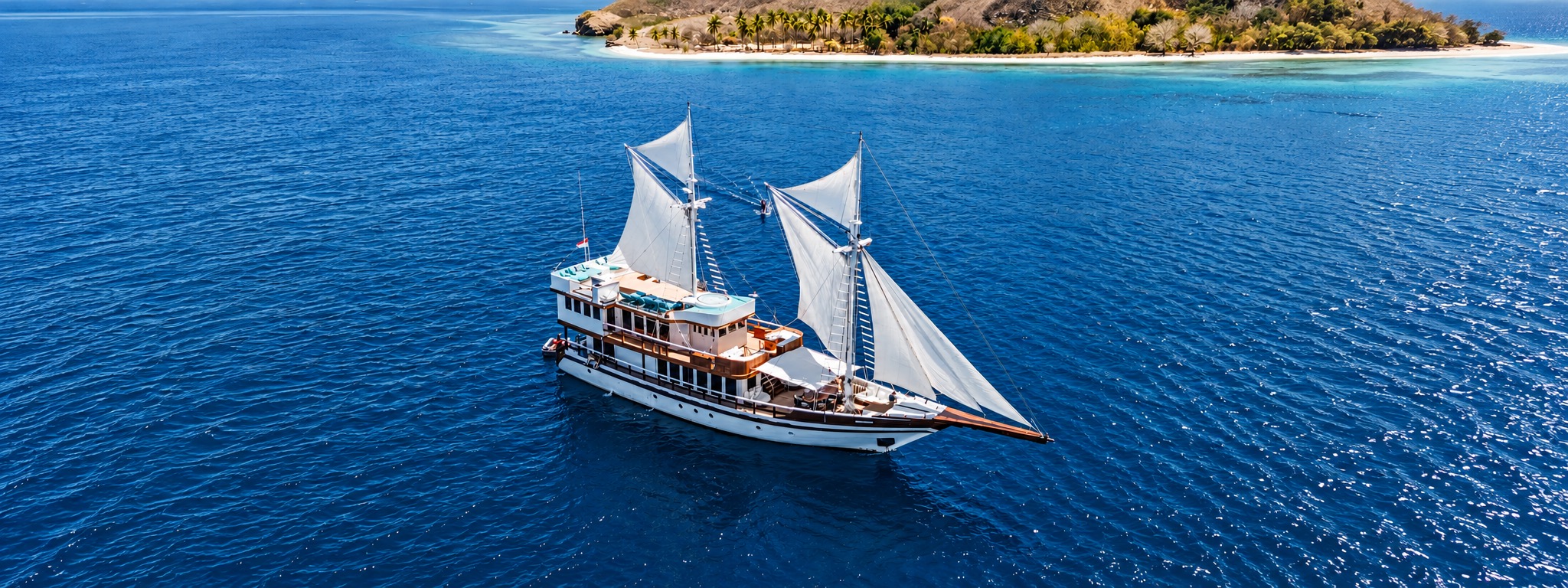 M/V KAYRA under sail off an island, seen from above